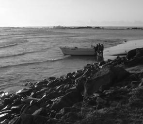 This boat has been rolled off the trailer and turned to face the waves.